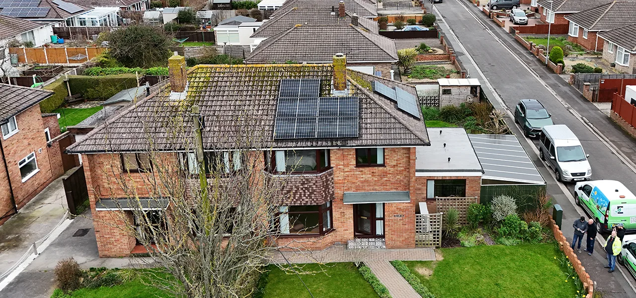Aerial view of homes with a house with solar panels installed